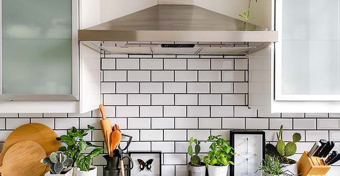 Modern subway-tile kitchen backsplash with eclectic decor.