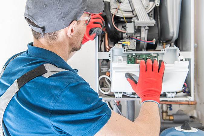 A technician fixing a furnace.