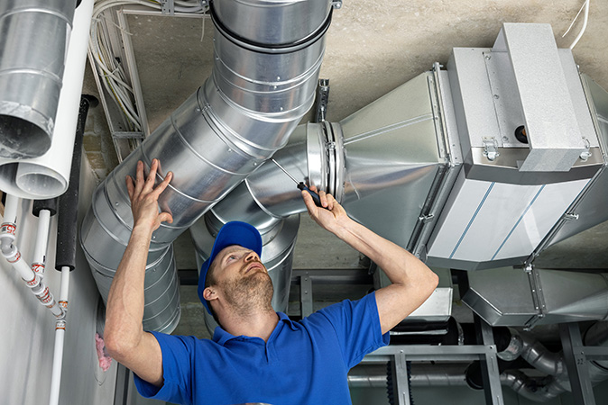 A technician inspects the ductwork in a home.