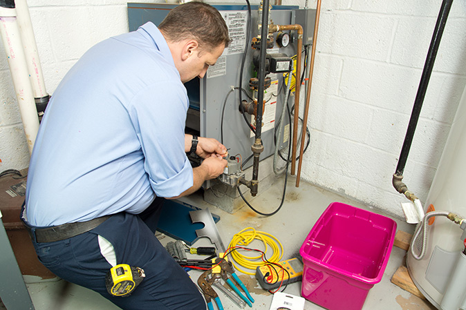 A technician repairing a home furnace.