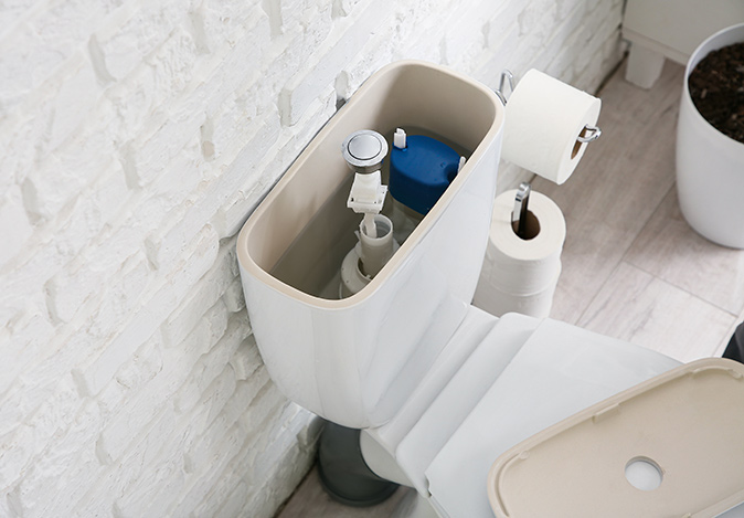 A toilet bowl with the tank lid removed for maintenance.