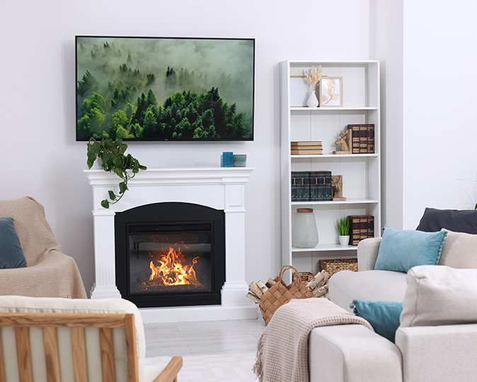 Seating is to the left and right of a TV above fireplace in bright white living room.