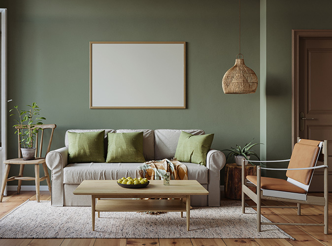 A living room that has been newly remodeled, with green painted walls and pillows on a couch, a wood coffee table and floor.