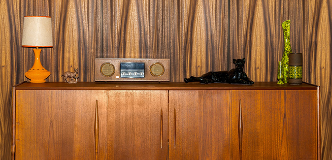 A 1970s or mid-century style living room with wood paneling.