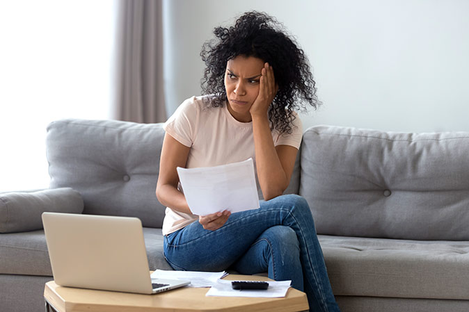 A woman worries over a utility bill that was unexpectedly high due to excessive water pressure.
